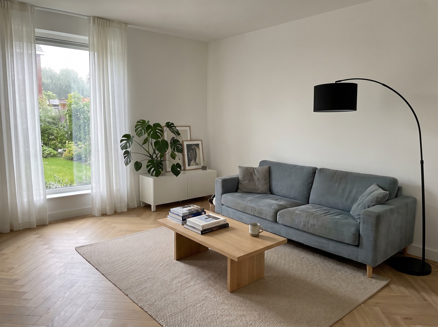 Woonkamer zoals de bezoeker hem fotografeerde, met de eigen grijsblauwe bank.