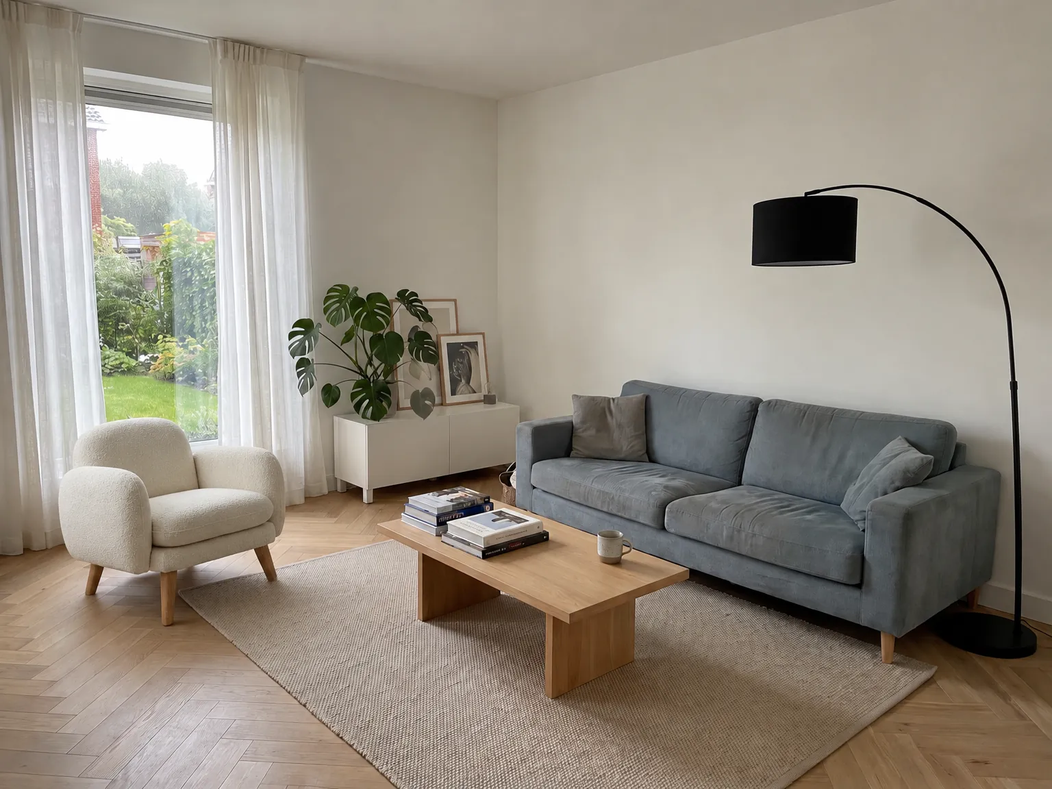 Een woonkamer met een grijsblauwe bank, een eikenhouten salontafel en een crèmekleurige bouclé fauteuil bij het raam. De fauteuil is door Veyra toegevoegd.